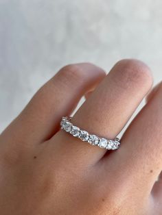 a woman's hand with a wedding band on it, and the ring has three stones