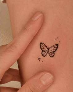 a small butterfly tattoo on the back of a woman's left shoulder and arm