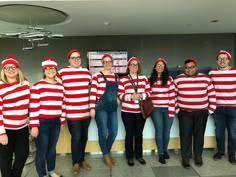 a group of people dressed in red and white striped sweaters posing for a photo