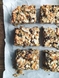 six squares of granola bars sitting on top of a piece of parchment paper