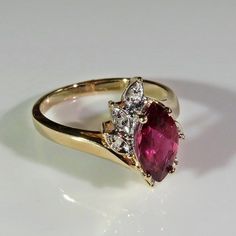 A beautiful large fine earth mined natural purple sapphire and diamond engagement ring circa 1970 handmade in solid 14K yellow gold and set with sparkly fine white diamond accents. This stunning ring is set with a rare purple sapphire which has a unique purple pink color. It's a gorgeous gem which would be hard to ever replace due to the amazing shade of purple of the fine sapphire. I adore the pretty asymmetrical setting with it's delicate splash of diamond accents. It is in excellent condition Elegant Marquise Ruby Ring With Vvs Clarity, Classic Marquise Ruby Ring With Brilliant Cut, Classic Marquise Ruby Ring With Vvs Clarity, Vintage Diamond Cluster Ring With Accent Stones, Classic Marquise Ruby Ring With Center Stone, Anniversary Ruby Ring With Marquise Cut Center Stone, Marquise Cut Ruby Ring With Center Stone For Anniversary, Vintage Ruby Ring With Accent Stones For Anniversary, Vintage 14k Gold Ruby Ring With Accent Stones