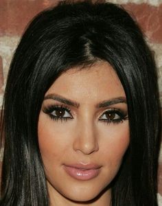 a close up of a person with long hair and eyeliners on her face