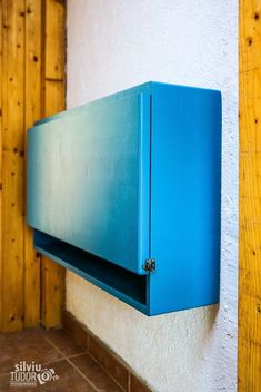 a blue cabinet mounted to the side of a wall