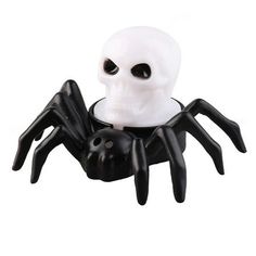 a white skull sitting on top of a black spider web toy in front of a white background