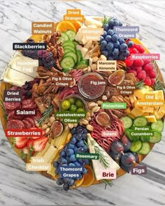 a plate filled with different types of fruits and vegetables on top of a marble table