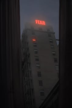 the word fear is lit up on top of a tall building