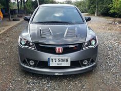 the front end of a car parked on gravel