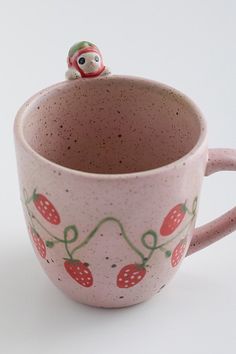 a ceramic cup with a small figurine sitting on top of the inside of it