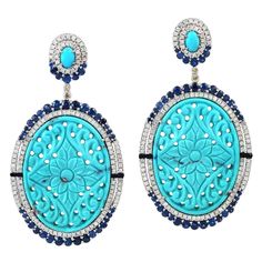 Cast from 18-karat gold and sterling silver. These earrings are set in 45.05 carats turquoise, 4.41 carats blue sapphire and 2.17-carats of diamonds. FOLLOW MEGHNA JEWELS storefront to view the latest collection & exclusive pieces. Meghna Jewels is proudly rated as a Top Seller on 1stDibs with 5 star customer reviews. All items manufactured by us are handmade and can be customized or redesigned. Size-62X33MM Total Weight-27.93 Gold Weight(Gms)-1.7 Silver Weight(Gms)-15.804 Diamond Wt(Cts)-2.17 B Turquoise Diamond Earrings, Victorian Drop Earrings, Sapphire Diamond Earrings, Art Deco Drop Earrings, Claw Earrings, Sapphire And Diamond Earrings, Diamond Cluster Earrings, Handmade Gemstone Jewelry, Diamond Dangle Earrings