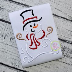 a snowman with a top hat and scarf on it's head is embroidered onto a white t - shirt