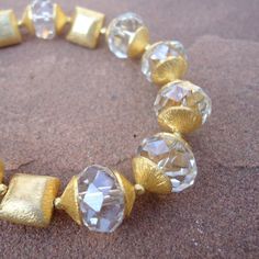 This crystal bracelet created by Jewelry by Carmal is made of: -Clear faceted rondelle crystals -24K gold vermeil bead caps -24K gold vermeil square beads -24K gold vermeil quatrefoil charm -14K gold filled beads -14K gold filled findings -14K gold filled toggle closure This clear crystal and gold bracelet measures 8 1/4 inches in length. The charm measures an additional 1/2 inch in length. View more beaded bracelets: http://www.etsy.com/shop/jewelrybycarmal?section_id=8002918 WE OFFER FREE STAN Faceted Crystal Bracelet For Weddings, Elegant Bracelet With Round Faceted Beads, Elegant Round Bracelets With Faceted Beads, Elegant Faceted Beaded Bracelets For Wedding, Faceted Round Crystal Bracelet For Weddings, Adjustable Faceted Beaded Bracelets For Wedding, Gold Jewelry With Faceted Beads For Formal Occasions, Formal Gold Jewelry With Faceted Beads, Elegant Crystal Beaded Bracelets With Faceted Details