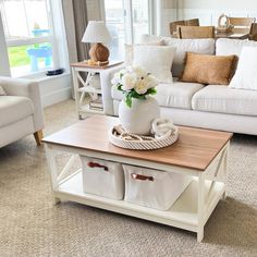 a living room filled with white furniture and lots of pillows on top of it's couches