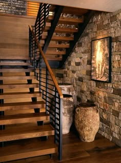 there is a vase next to the stairs in this house with stone walls and wood railings