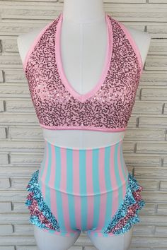 "This two piece sets includes a halter top with deep v-neck in ballet pink spandex with sequins. Wide under bust elastic, trimmed in pink stretch satin elastic keeps everything in place. Fully lined bust with removable foam cup inserts. The high waist briefs are nylon/spandex in 1/2\" ballet pink and aqua stripes with wide, double layer waistband. Hip flattering triple flounces at the leg line, finished off in self fabric binding. The briefs are a low, vintage style leg line and fully lined in b Pink Triangle Halter Top For Party, Pink Fitted Halter Neck Top, Pink Stretch Triangle Halter Top, Fitted Sequin Halter Neck Top, Sequined Fitted Halter Neck Top, Hot Pink Jazz Dance Costumes, Pink Fitted Dancewear Bodysuit, Pink And Purple Dance Costume, Summer Dancewear Pink Leotard