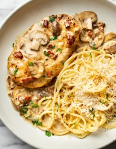 a white plate topped with chicken, pasta and mushrooms