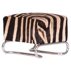 a zebra print foot stool with chrome legs