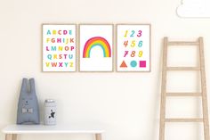 three children's art prints on the wall above a white table with a ladder