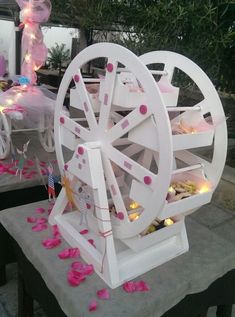 a white ferris wheel with pink petals on the ground