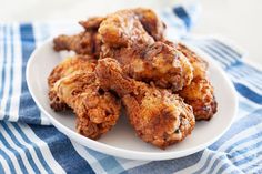 fried chicken on a white plate sitting on a blue and white towel