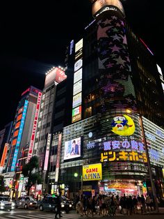 a busy city street at night with tall buildings