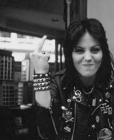 a black and white photo of a woman giving the peace sign with her hand in front of her