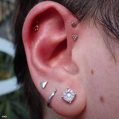 an ear with three different piercings on it