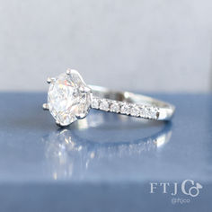 a diamond ring sitting on top of a table