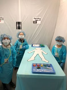 four doctors in scrubs stand next to a table