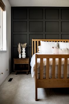 a bedroom with black walls and white bedding