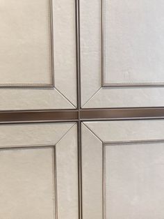 the corner of a kitchen cabinet door with metal trim