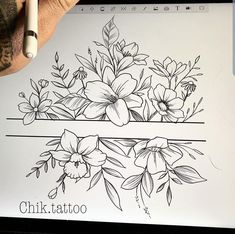 a person holding a pen and drawing flowers on a sheet of paper with the word chik tattoo