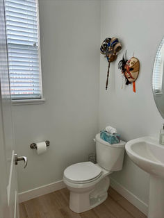 a white toilet sitting in a bathroom next to a sink