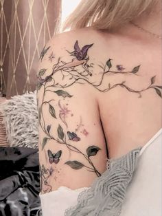 a woman's shoulder with flowers and butterflies on it