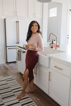 a woman in a kitchen leaning on the counter