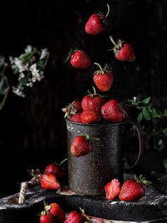 a bucket full of strawberries falling into the air