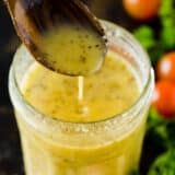 a glass filled with liquid sitting on top of a table next to tomatoes and broccoli