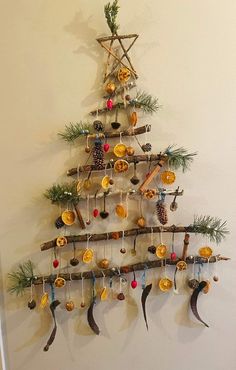 a christmas tree made out of wooden sticks and other ornaments hanging on the wall next to a door