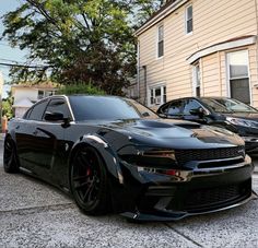 a black sports car parked in front of a house