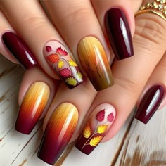 A gradient nail design that transitions from deep burgundy at the base to a golden yellow at the tips. Each nail features delicate, hand-painted autumn leaves in various stages of color change, from green to red to brown. Trendy Autumn Nails, Autumn Nails Ideas, Tree Nail Art, White Tips, Seasonal Nails, Colorful Nails, Diy Nail Designs, French Tips