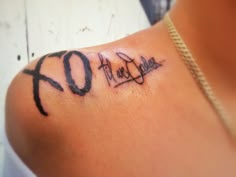 a woman with a tattoo on her shoulder that says love and the word hope written in cursive font