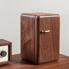 an old fashioned radio sitting on top of a wooden table next to a wood box