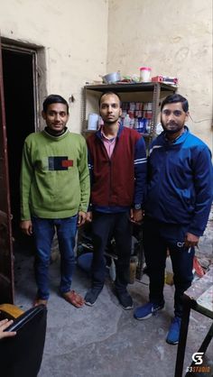 three men standing in front of a doorway