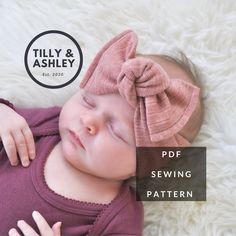 a baby sleeping on top of a white blanket wearing a pink bow tie headband