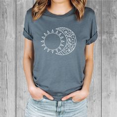 Women's Bella Tri-Blend relaxed unisex fit T-shirt with a Sun and Moon screen printed graphic design.  Super soft, stretchy, and comfy material.   Available with black or white ink! FIT: Follow the image size chart Unisex Fit - Runs Large - Long Length  Suggest sizing down if you prefer a more fitted look instead of relaxed -  Bella 3.8 oz  Super Soft hand and lightweight  -  Tri Blends:  50% Poly, 25%  Cotton, 25%  Rayon -  Does not shrink -  Hand screen printed to order in Oregon - Model is wearing a size small Fashion Fitted Style  http://etsy.me/2qjx3lC ♥ All of our tees are hand-printed to order in our shop in Portland Oregon! ♥ RETURNS & EXCHANGES We gladly accept exchanges and returns if not worn.   Please follow the chest measurement size guide for fit if you are unsure.  We custom Casual Short Sleeve T-shirt With Moon Print, Casual Summer T-shirt With Sun And Moon Design, Casual Cotton T-shirt With Moon Print, Cotton Crew Neck Top With Moon Print, Cotton Graphic Tee With Moon Print, Relaxed Fit Graphic Tee With Moon Print, Trendy Moon Print Crew Neck Top, Trendy Crew Neck T-shirt With Moon Print, Relaxed Fit Moon Print Graphic Tee