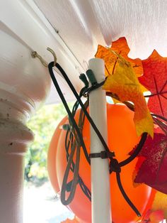 some orange and red umbrellas hanging from a white pole