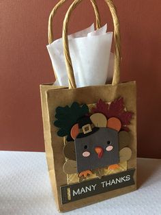 a paper bag with a turkey on it and the words many thanks written on it