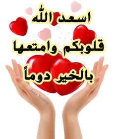 two hands holding red hearts with arabic writing on the top and below it, in front of