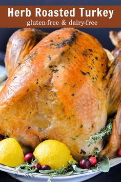 a roasted turkey on a platter with lemons and cranberry garnish