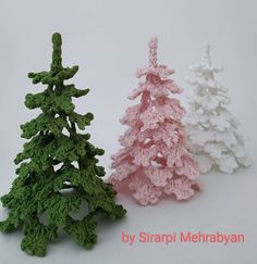 three crocheted christmas trees sitting next to each other