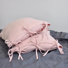 two pink pillows tied together on a bed